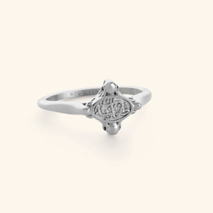 Minimal silver ring with "in our hearts" inscription on its plate.