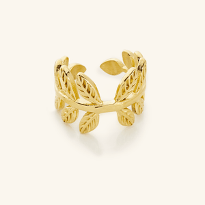 Close-up of a gold Olive Branch Ring featuring an open wrap design with textured leaf details around the band.