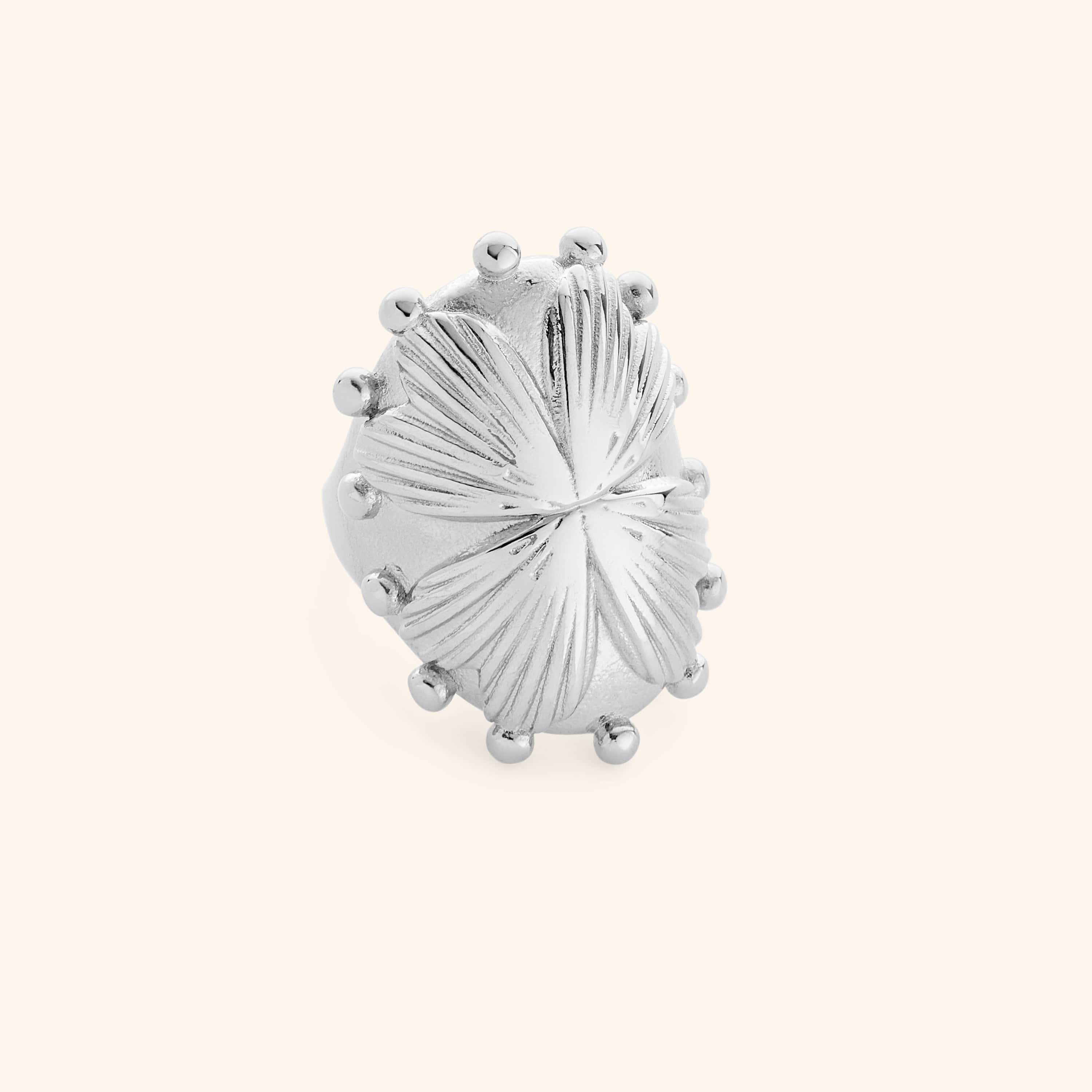 Close-up of silver regal garden ring with textured leaf design and raised bead accents.