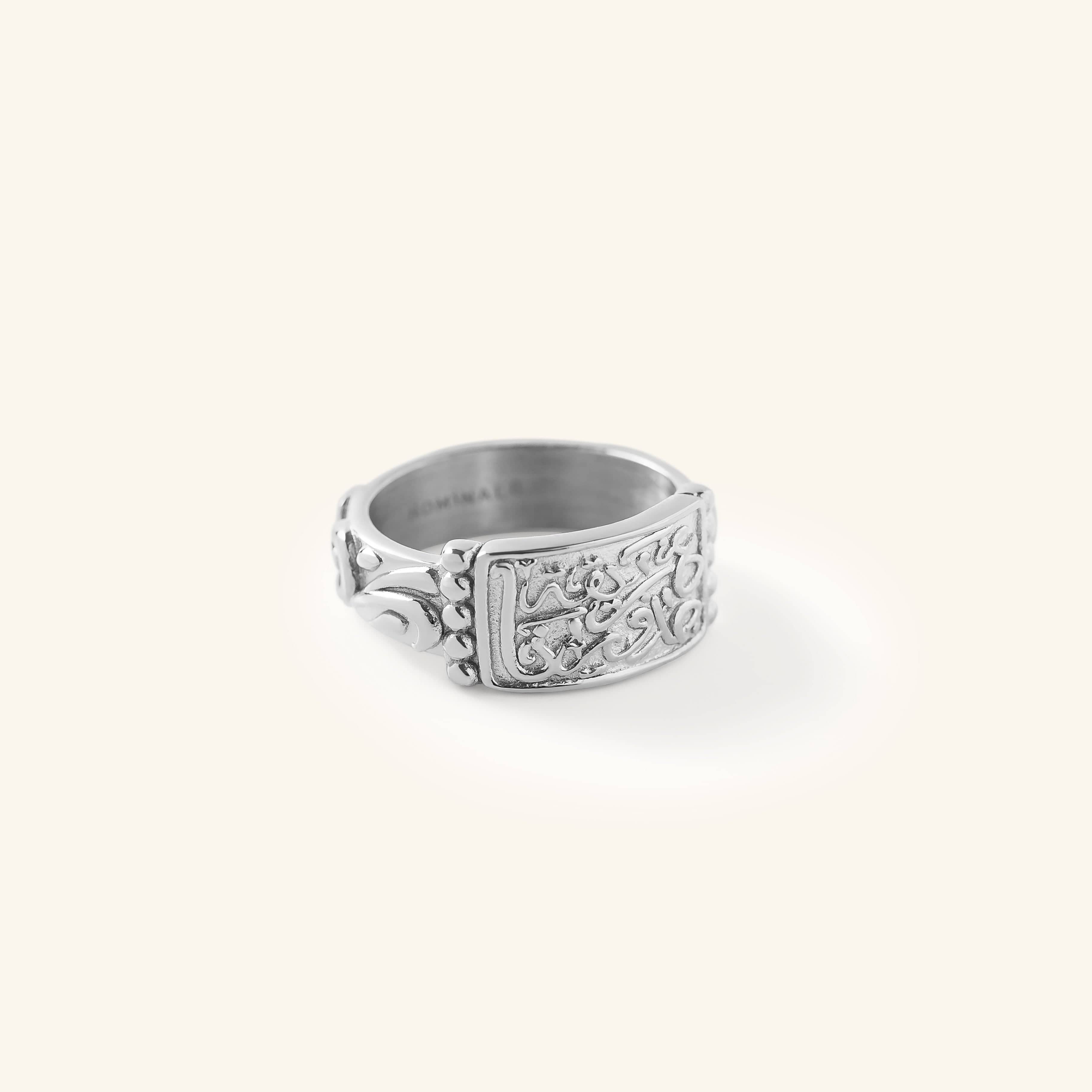 Silver “Our Roots Run Deep” Ring featuring raised Arabic calligraphy and textured detailing across a wide band, shown against a neutral background.