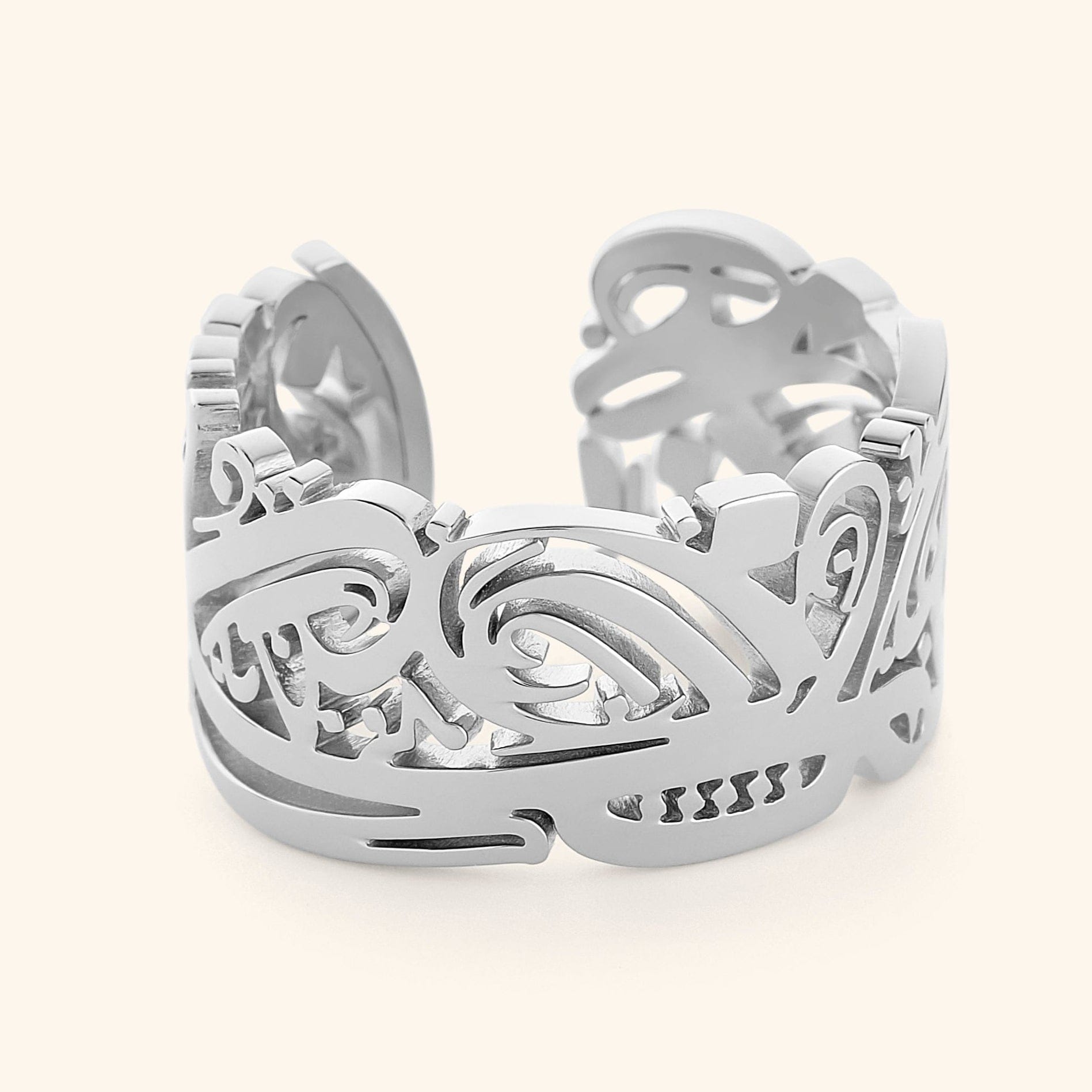 Silver Ease ring with intricate Arabic calligraphy cutout design, wide band with smooth polished edges, photographed against a light background.