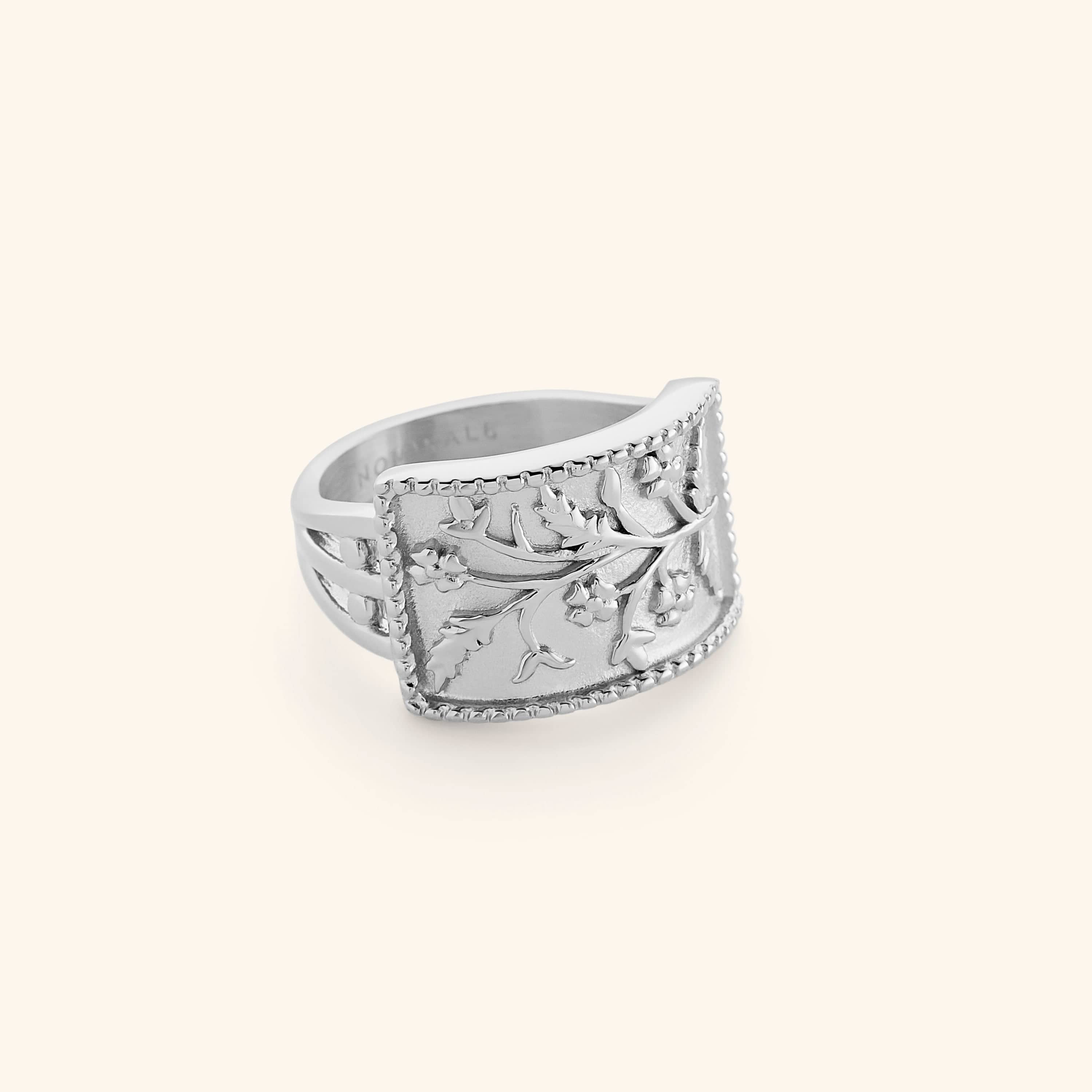 Silver Garden Ring with a curved rectangular face engraved with delicate floral vines and beaded edges.
