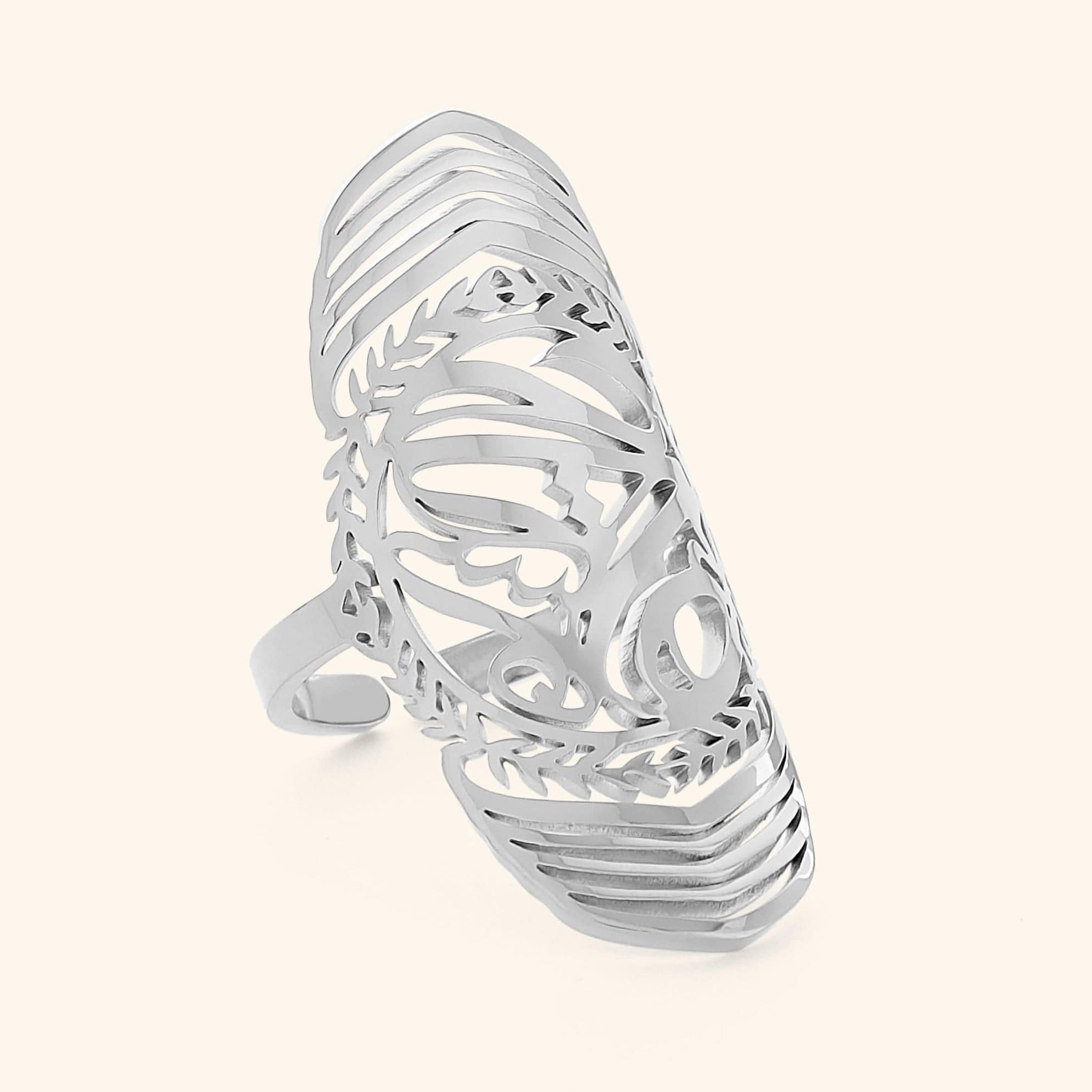 Close-up of a silver Sufficient ring featuring intricate Arabic calligraphy cutout design, photographed against a neutral background.