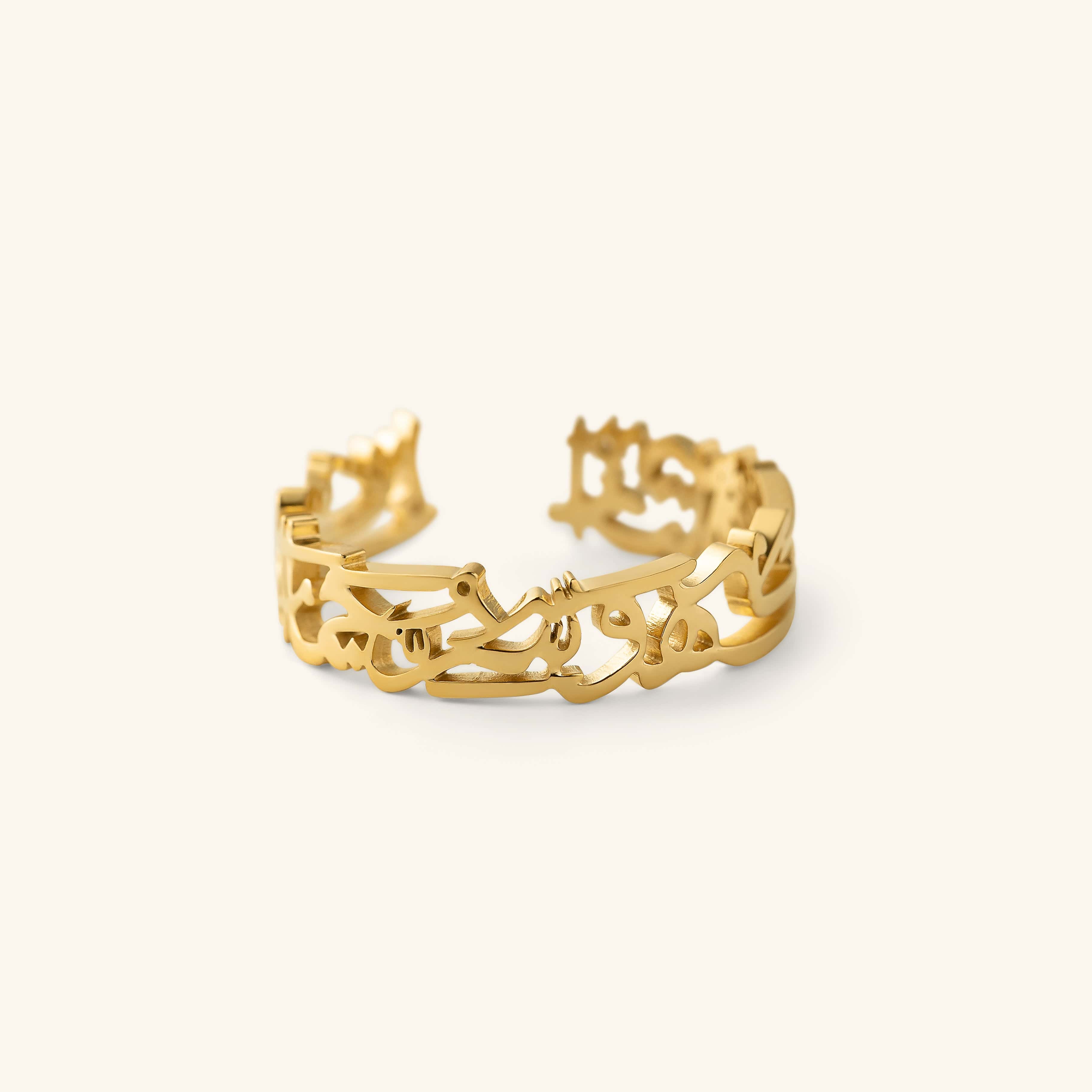 Gold “What Makes You Different Makes You Beautiful” Calligraphy Ring shown in a close-up shot, featuring an open band with cutout Arabic calligraphy.