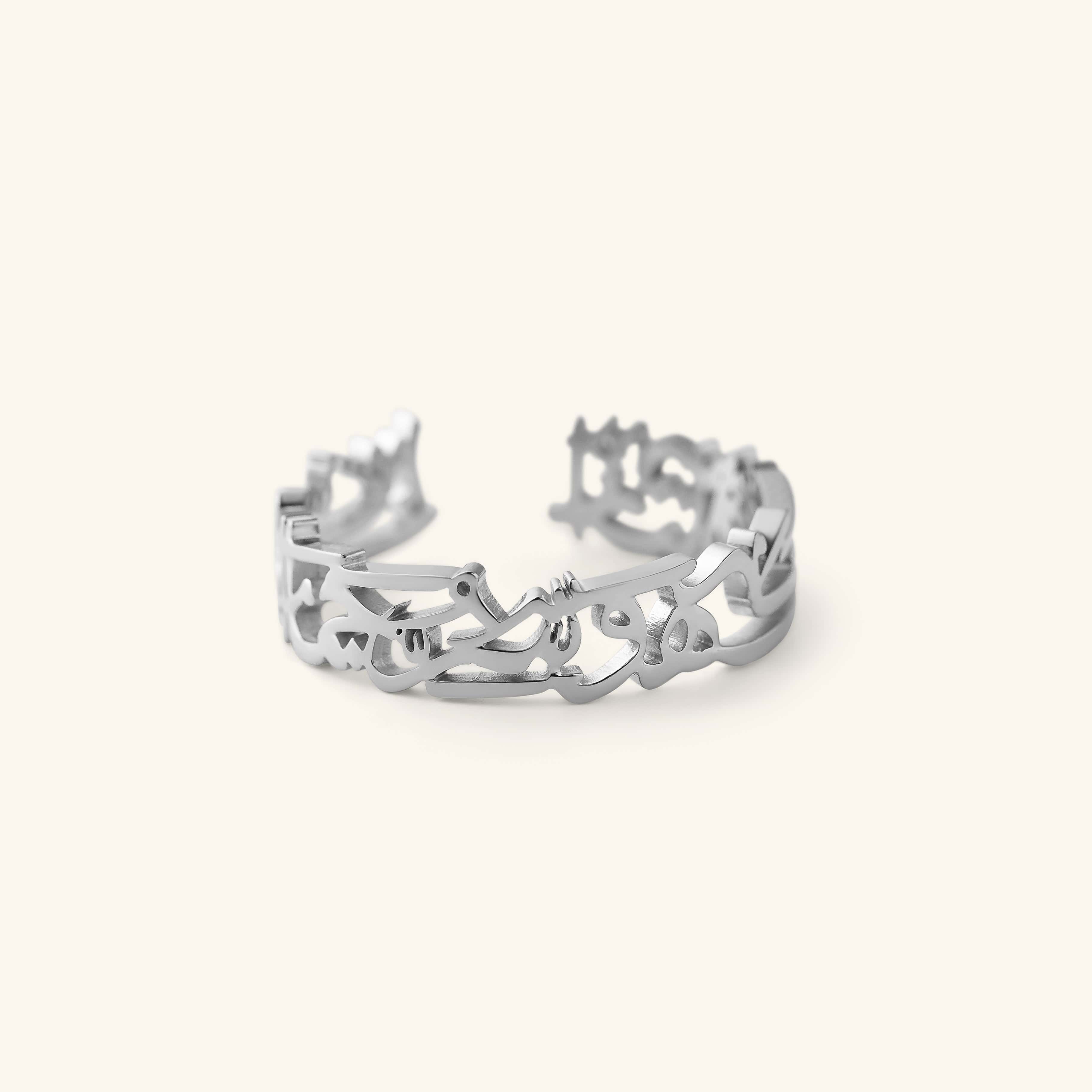 Silver “What Makes You Different Makes You Beautiful” Calligraphy Ring shown in a close-up shot, showing the open band and Arabic calligraphy.