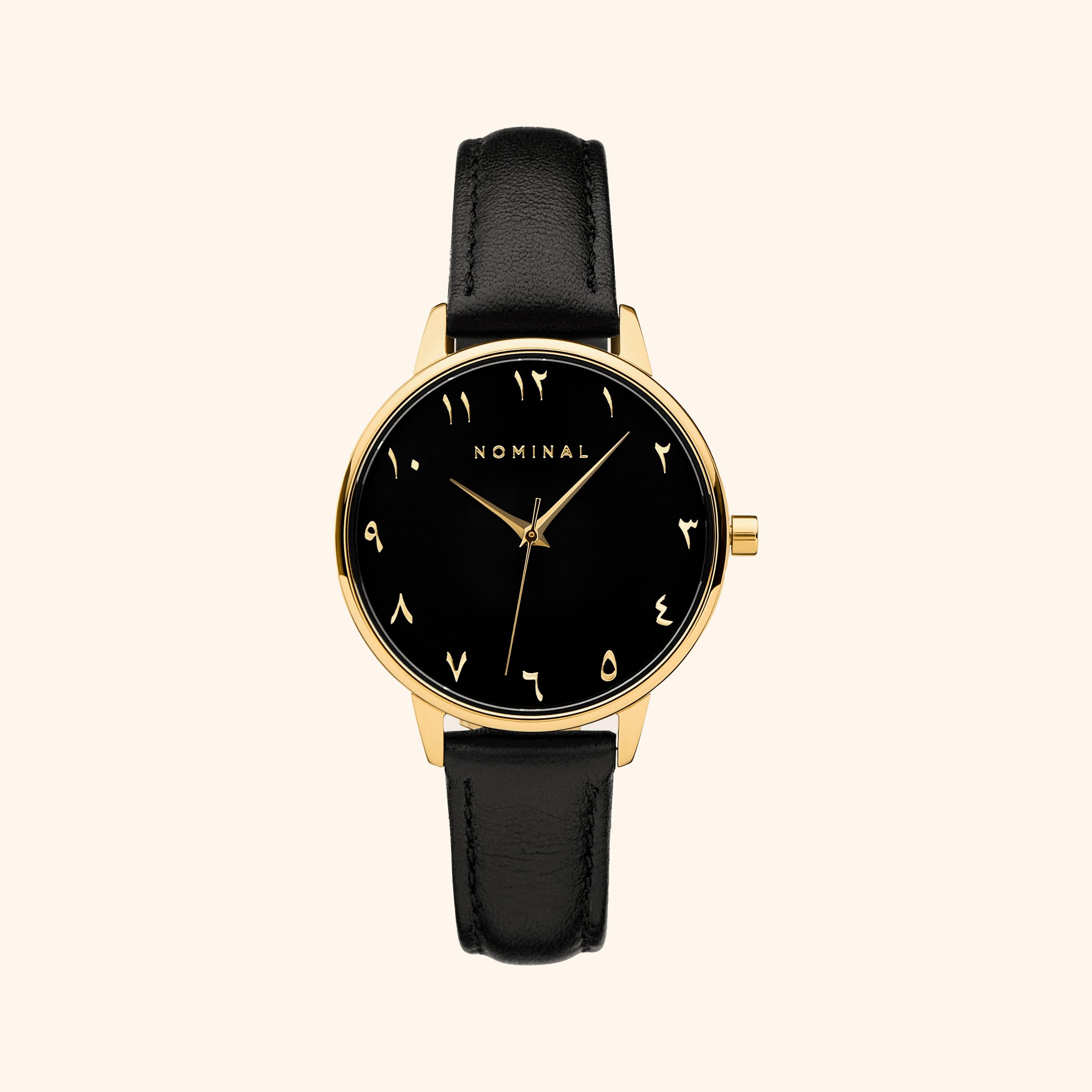 Black mesh strap watch with minimalist Arabic numerals and gold details, displayed against a neutral background